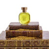 arquiste l'or de louis perfume on top of books