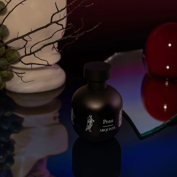arquiste peau perfume bottle on a table 