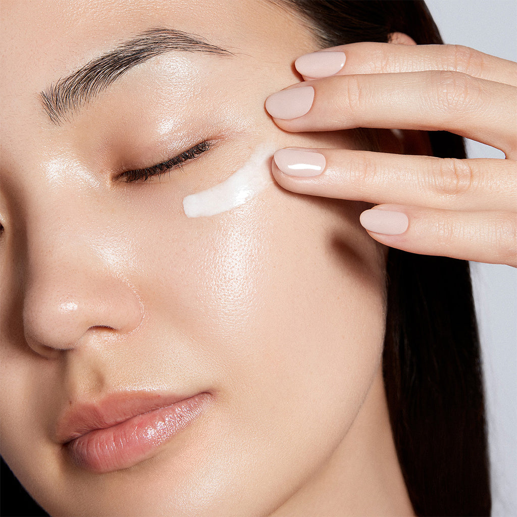 woman applying augustinus bader the eye cream