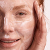 woman using augustinus bader the foaming cleanser on face
