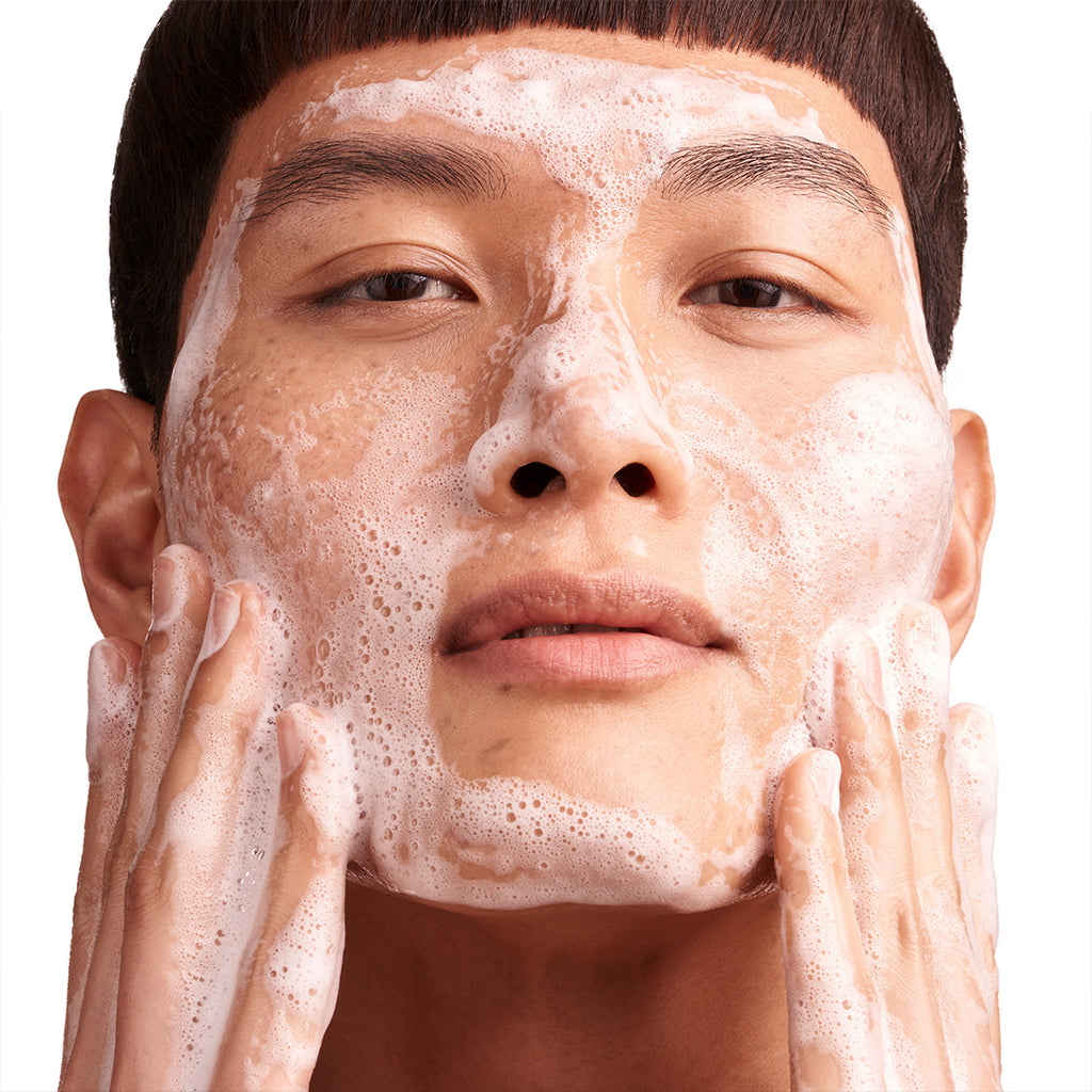 man using augustinus bader the foaming cleanser on face