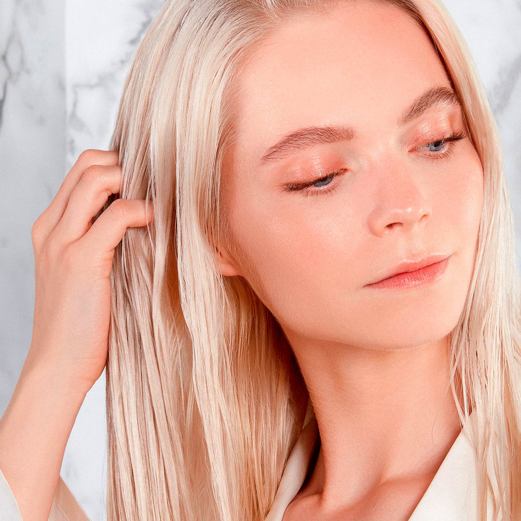 woman applying augustinus bader the leave in hair treatment to their hair