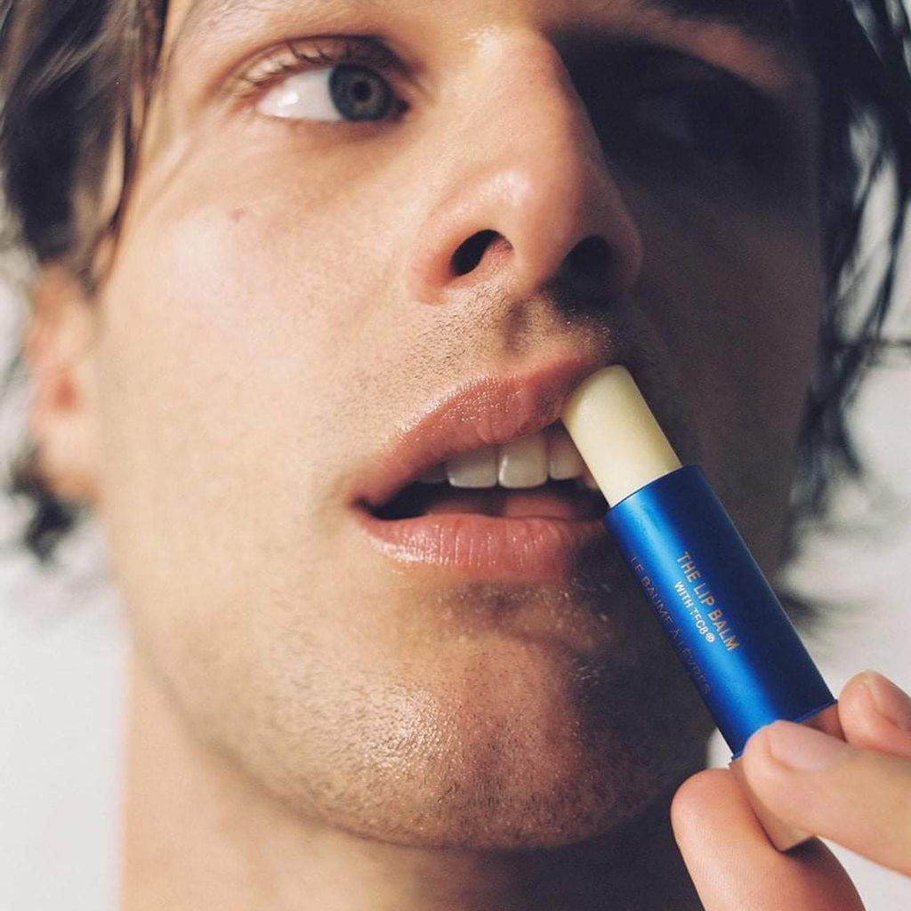 man applying augustinus bader the lip balm